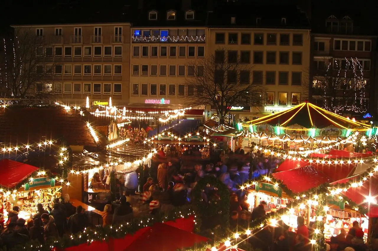 Overzicht van de verlichte kramen op de Markt in Aken bij avond