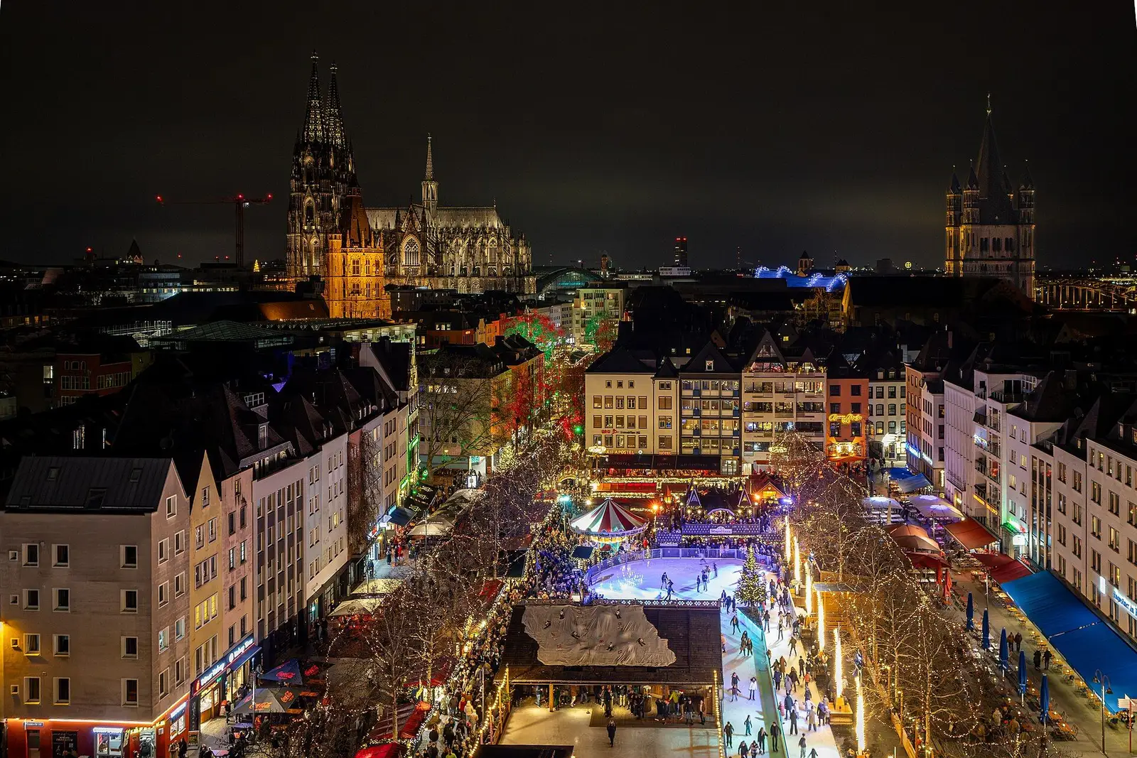 Heinzels Wintermärchen op de Heumarkt in Keulen, met de schaatsbaan tussen de kramen bij avond