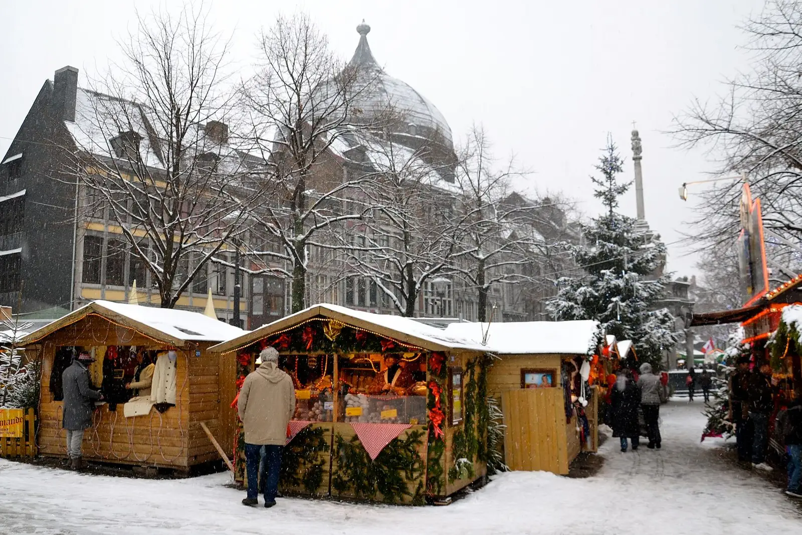 Houten chalets van het Village de Noël in Luik in de sneeuw