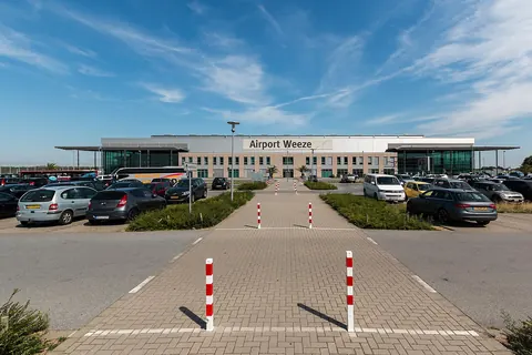 Het terminalgebouw van Airport Weeze met de parkeerplaats ervoor