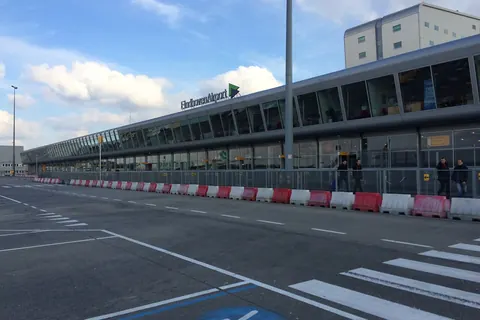 Het lange terminalgebouw van Eindhoven Airport aan de kant van de weg