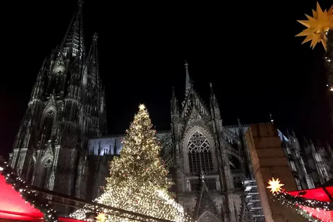 De Dom van Keulen bij avond met de kerstboom en de kramen van de markt op het Roncalliplatz