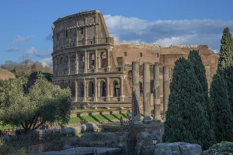 Het Colosseum in Rome, gezien vanaf het Forum Romanum met cipressen op de voorgrond