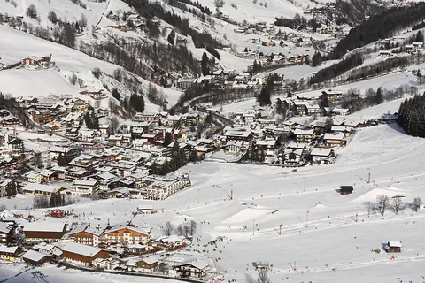 Het besneeuwde dorp Hinterglemm in het dal, gezien vanuit een skilift